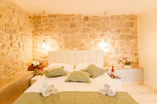 a bedroom with a white bed with towels on it at Stone house luxury rooms in Split