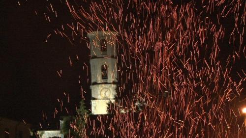 a clock tower at night with red sparks at Hotel Ruffirio in Vinchiaturo