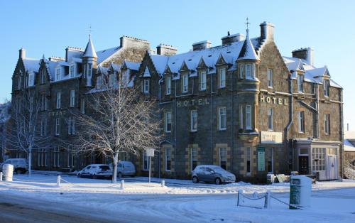 a large building with cars parked in front of it at Grant Arms Hotel in Grantown on Spey