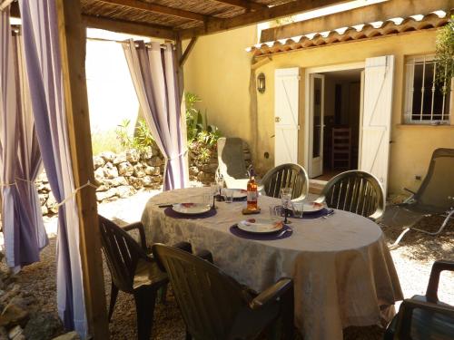 a table and chairs in a patio with a table and chairs at Gîte de Saint Cassien in Montauroux