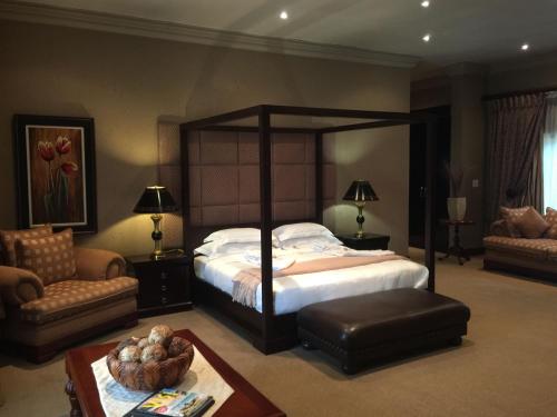 a large bedroom with a large bed and a table at Witwater Guest House & Spa in Kempton Park