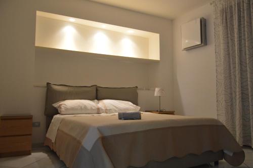 ノートにあるCasa Vacanze Le Palmeのベッドルーム1室(ベッド1台、上部にライト付)