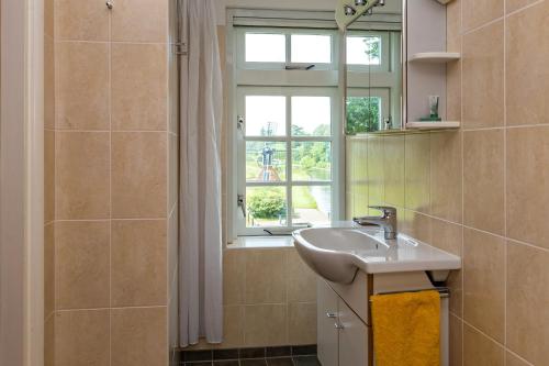 baño con lavabo y ventana en Private Island De Sayter, en Warten