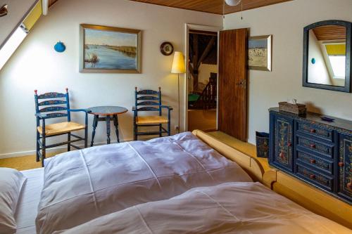 1 dormitorio con 1 cama, mesa y sillas en Private Island De Sayter, en Warten