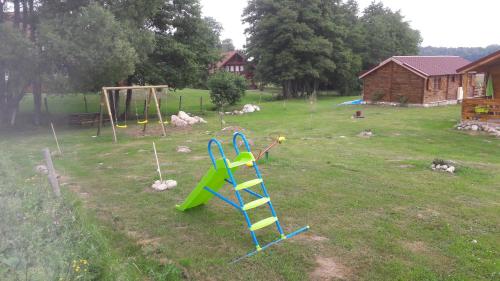 a yard with a playground with a slide at chalets les 5 loups in Gerbépal