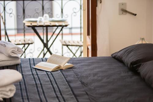 a book sitting on top of a bed with a table at Le Stanze Di Brando E Nico in Tricase