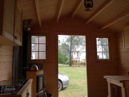a kitchen with windows and a car in the yard at Tammispää Camping in Lohusuu