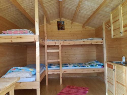 a bedroom with bunk beds in a wooden cabin at Tammispää Camping in Lohusuu
