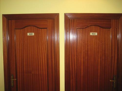 two wooden doors are next to each other at Hostal El Pinar in Avila