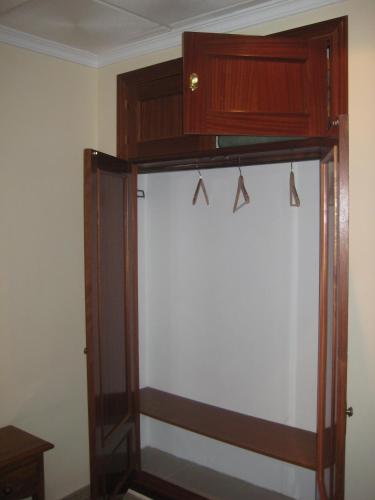 a closet in a room with a wooden cabinet at Hostal El Pinar in Avila