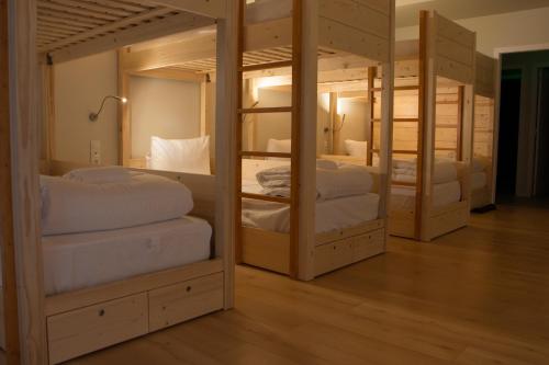Habitación con 4 literas y almohadas blancas. en Feira Hostel & Suites, en Santa Maria da Feira