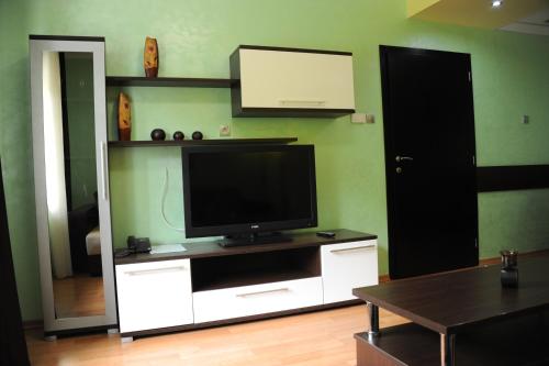 a living room with a television on a white entertainment center at Clinic for Rehabilitation Vujan in Čačak