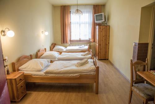 grupa czterech łóżek w pokoju z oknem w obiekcie Hotel Azyl w mieście Gorzów Wielkopolski