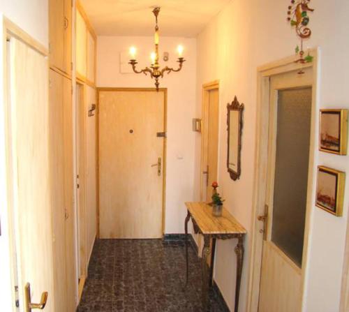 a hallway with a wooden table and a chandelier at Teja Apartment in Split