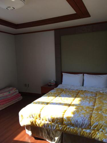 a bedroom with a bed with a quilt on it at The Beauty Hotel in Gangneung