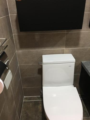 a bathroom with a white toilet and a toilet paper dispenser at The Beauty Hotel in Gangneung