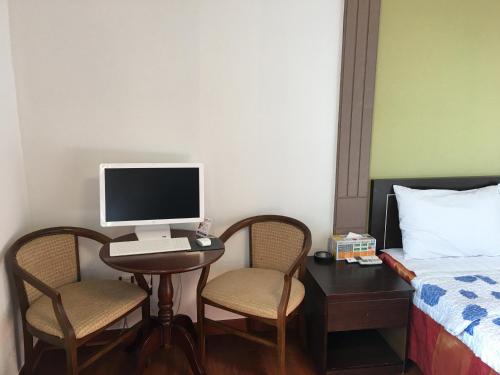 a bedroom with a desk with a computer and two chairs at The Beauty Hotel in Gangneung