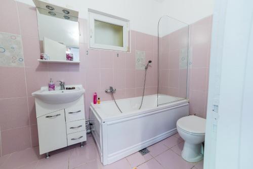 クルジュ・ナポカにあるMeda Apartmentsのピンクのバスルーム(バスタブ、シンク、トイレ付)