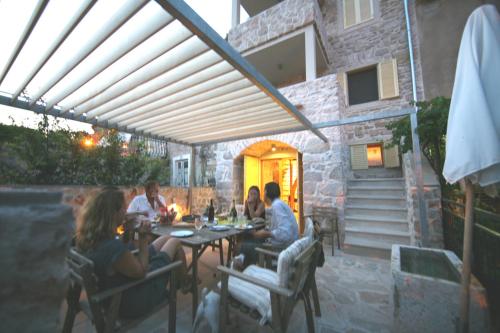 un gruppo di persone seduti a un tavolo su un patio di Stone House Nana a Zlarin (Zlarino)