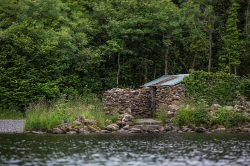 a stone building next to a body of water at Lusty Beg Island in Kesh