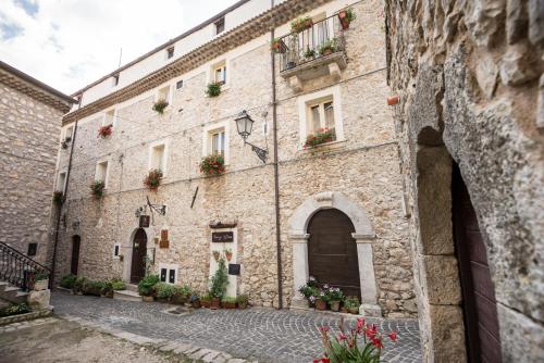 un viejo edificio de piedra con cajas de flores. en Nenà Al Borgo Castello, en Pico