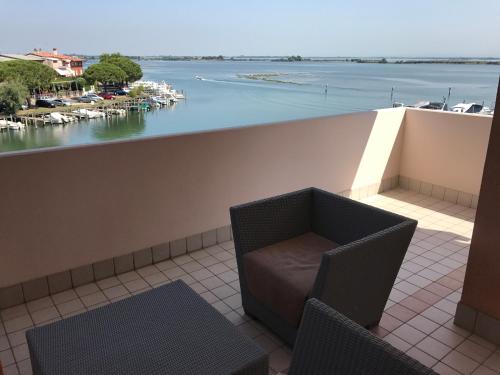 a balcony with chairs and a view of a marina at Aparthotel Capitol in Grado