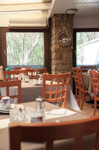 a dining room with tables and chairs and a stone wall at Kurparkhotel-Gemünd in Gemünd
