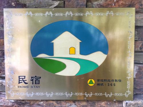 a sign for a home stay on a building at Cingjing Four Seasons B&B in Renai