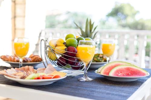a table topped with plates of fruit and glasses of orange juice at Apartments The heart of Croatia in Pirovac