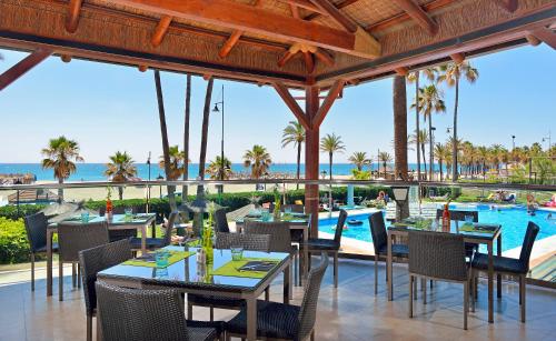 
a dining room with tables and chairs and umbrellas at Sol Principe in Torremolinos
