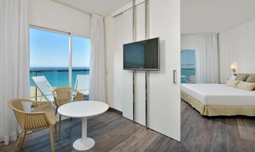 Habitación de hotel con cama, mesa y TV. en Sol Principe, en Torremolinos