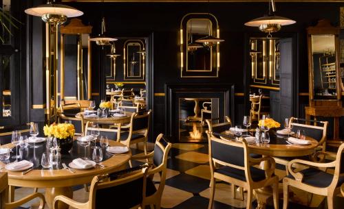 a dining room with tables and chairs and a fireplace at Blakes Hotel in London