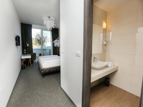 a bathroom with a sink and a mirror at Barbara Piran Beach Hotel in Piran