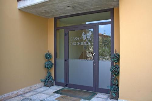 a door to a building with a sign on it at Casa Orchidea Apartments in Torri del Benaco