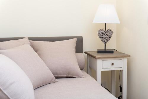a bed with a table with a lamp on it at Relais Dei Mandorli in Bergamo