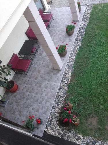 a patio with chairs and plants and grass at Apartmani Radulović in Vrnjačka Banja