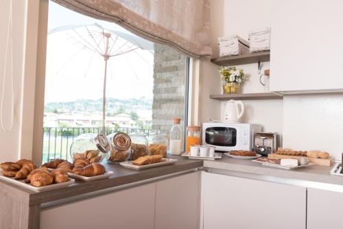 a kitchen counter with plates of bread and a window at Relais Dei Mandorli in Bergamo