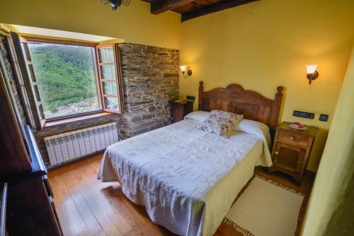 a bedroom with a bed and a large window at A Casoa in Santa Eulalia de Oscos