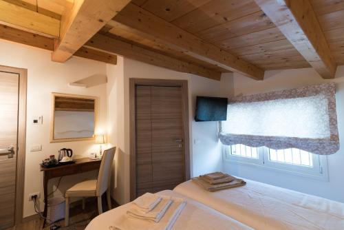 sypialnia z łóżkiem, biurkiem i oknem w obiekcie Relais Dei Mandorli w Bergamo