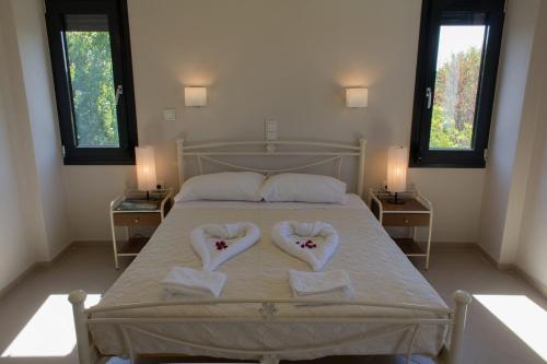 a bed with two towels in the shape of hearts at Perivoli House A in Skala Eresou