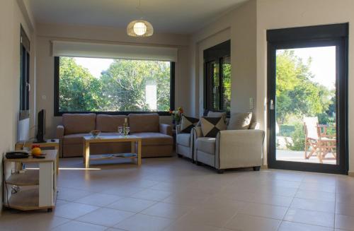 a living room with a couch and chairs and a table at Perivoli House A in Skala Eresou