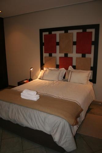 a bedroom with a large bed with a large headboard at De Vagebond Hotel-Pension in Windhoek