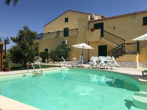a swimming pool in front of a building at Casa Vacanze Agriturismo Cilone in Ragusa