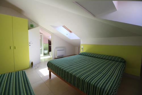 - une chambre avec des murs verts et blancs et un lit dans l'établissement Appartamenti Solemare, à San Benedetto del Tronto