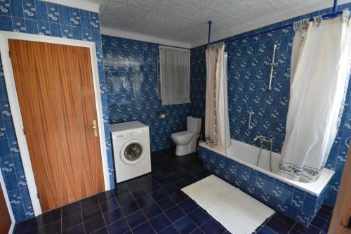 La salle de bains bleue est pourvue de toilettes et d'un lave-linge. dans l'établissement Lloret Apartments, à Lloret de Mar