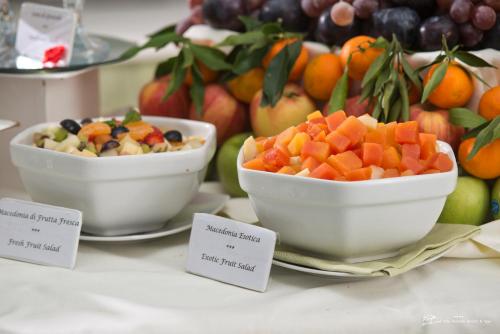 two bowls of fruit on plates on a table at Hotel Villa Durrueli Resort & Spa in Ischia