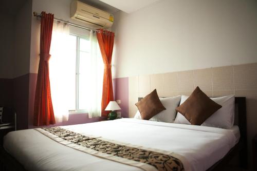 a bedroom with a large white bed and a window at Ratchada 17 Place in Bangkok