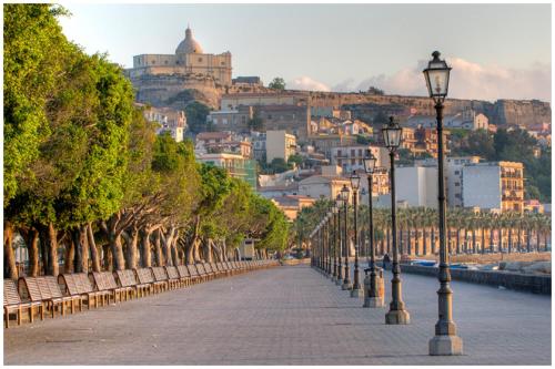 a row of street lights on a sidewalk in front of a city at B&B Varadero in Milazzo