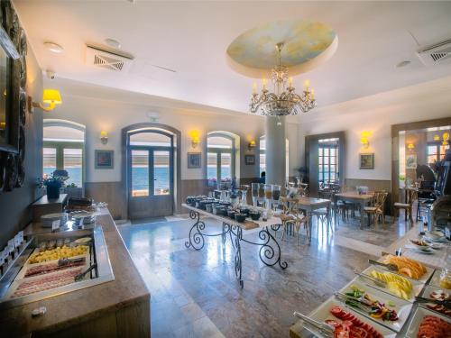 a restaurant with tables and chairs and a chandelier at Hotel Piran in Piran