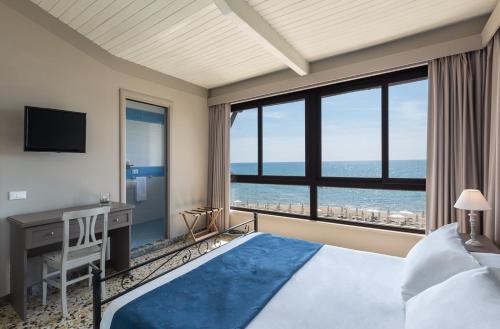 a bedroom with a bed and a desk with a view of the ocean at Antica Villa in Gaeta